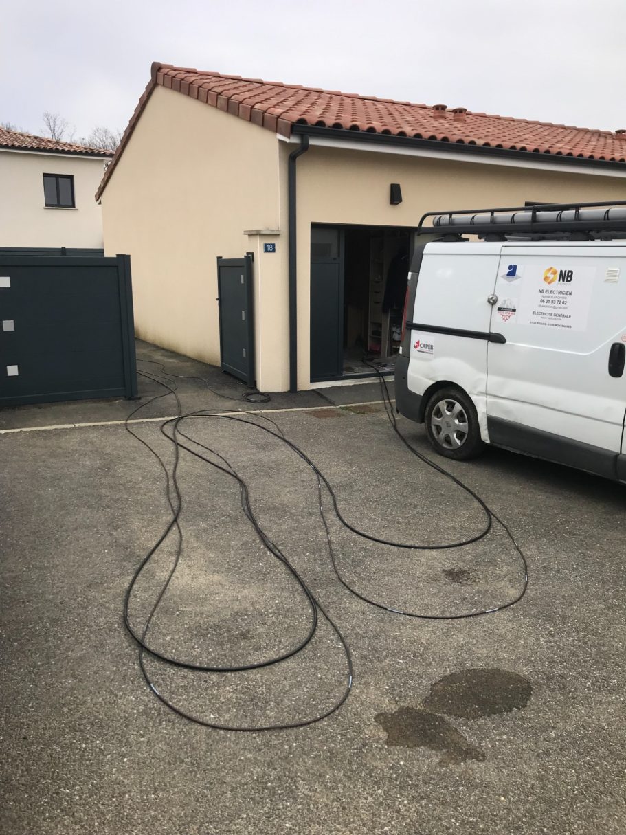 Intervention électrique chez un particulier Fourgon d'artisan électricien stationné devant une maison individuelle.