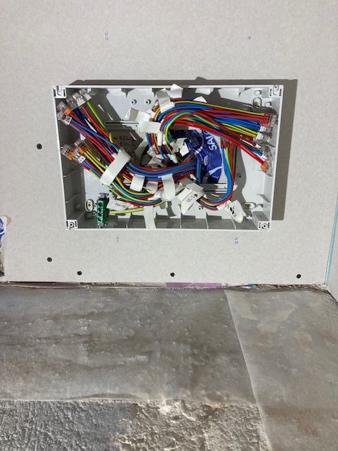 Câblage d'un coffret électrique Coffret électrique ouvert avec de nombreux conducteurs multicolores en cours de raccordement.