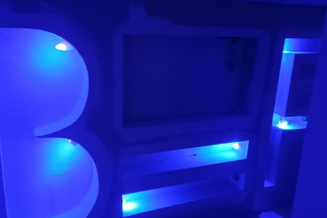 Éclairage LED bleu intégré dans un mur pour une finition lumineuse moderne.